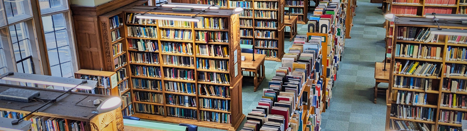 A shot of the Haddon Library space from one of our balconies showing lots of oak shelving and cosy tables offering lots of study spaces