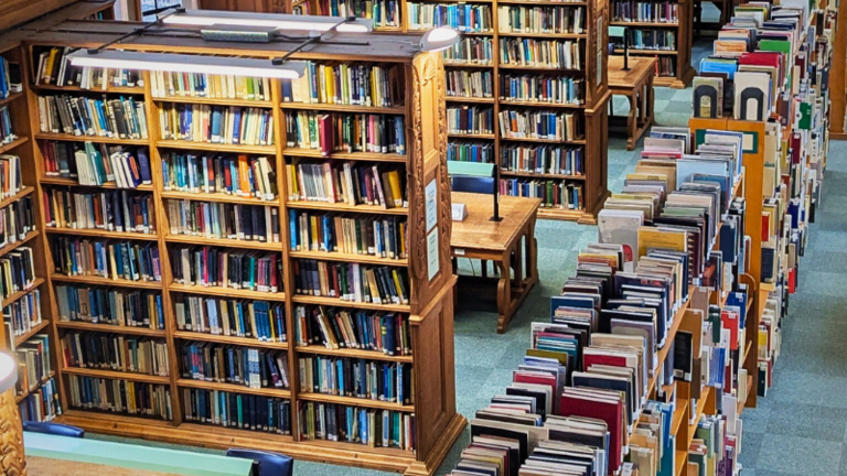 A shot of the Haddon Library space from one of our balconies showing lots of oak shelving and cosy tables offering lots of study spaces