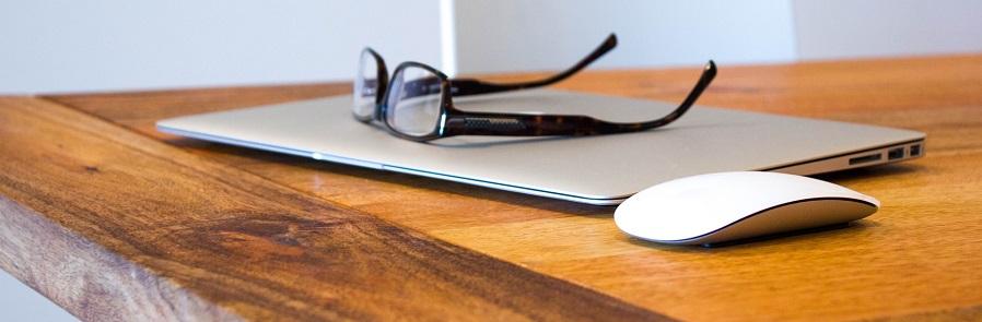 Photos of glasses and a computer mouse on a wooden desk